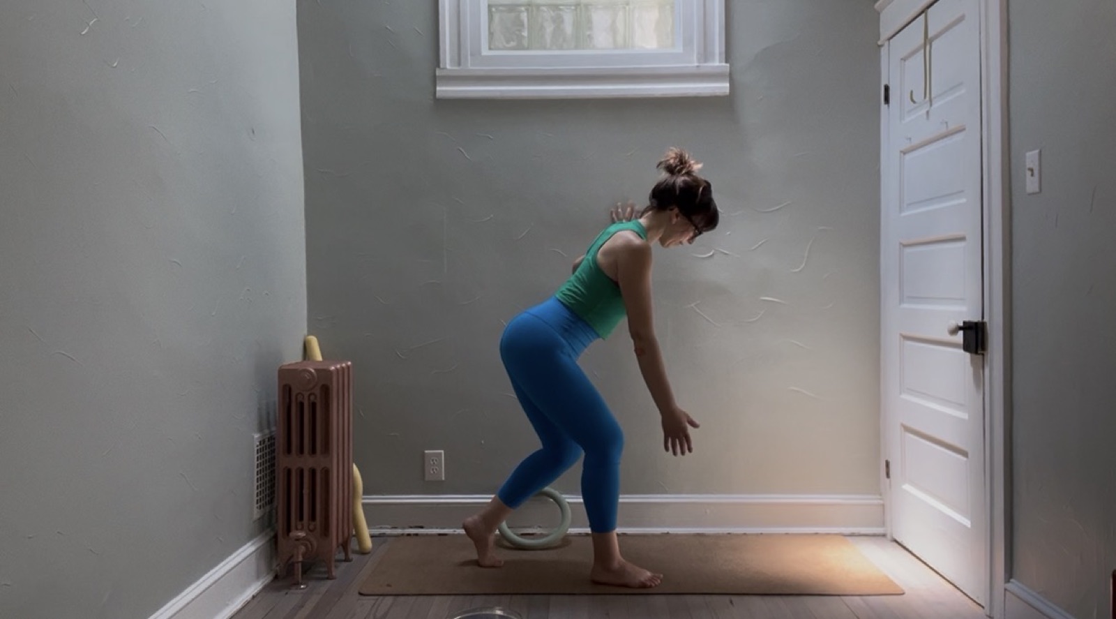 Still from a Tidal Work practice video — a standing fold on a mat